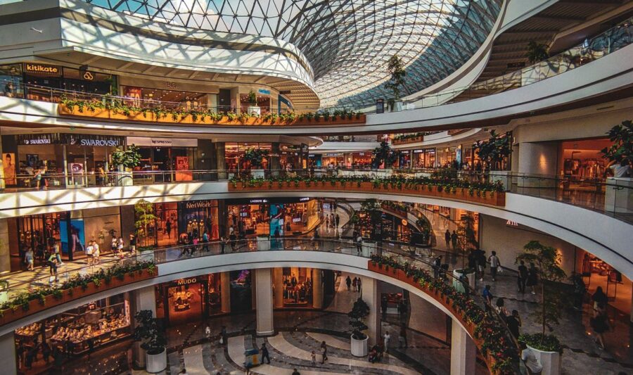 Interior de un centro comercial moderno con techo de vidrio